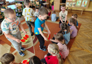 Chłopcy z grupy "Żabki" wręczają upominki dziewczynkom.