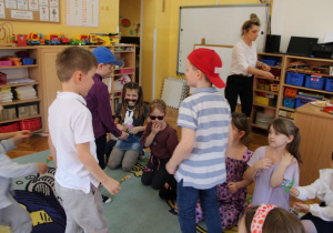 Chłopcy wręczają dziewczynkom kwiatki z okazji Dnia Kobiet.