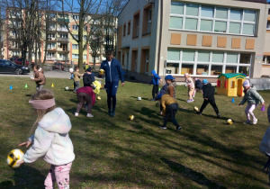 Krasnoludki biegają za piłką.