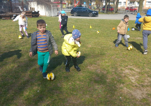 Dzieci bawią się piłkami.