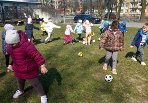 Dzieci kopią piłkę.