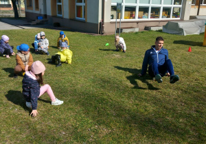 Przedszkolaki siedzą na piłce.