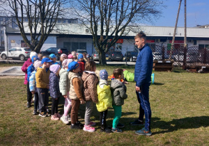 Krasnoludki stoją przed trenerem ustawione w pociąg.