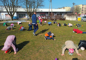 Dzieci czołem starają się trzymać kokosa - piłkę.