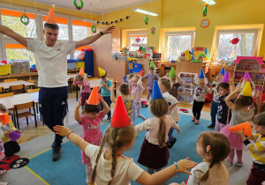 Przedszkolaki próbują utrzymać rożki-czapeczki na głowach