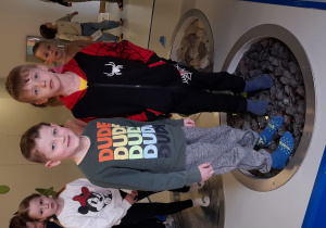 Franek i Antek eksplorują instalację z naturalnymi elementami, chodząc po kamieniach o zróżnicowanej strukturze.