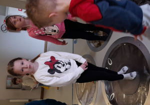 Michalinka poznaje zróżnicowane struktury wodne, stojąc na elemencie ścieżki sensorycznej.