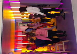 Dzieci przechodzą przez tunel multisensoryczny, doświadczając różnorodnych bodźców świetlnych, dźwiękowych i dotykowych.