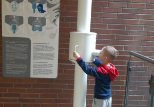 Leonek obserwuje przez peryskop wyższe piętra EC1 Łódź.