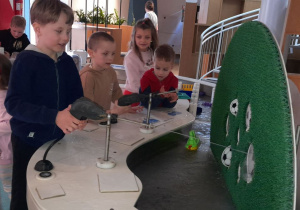 Kasjan i Jaś kierują strumieniem z armatki wodnej, próbując trafić w wyznaczone cele.