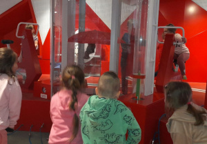 Dzieci wprawiają elementy w ruch, odkrywając, jak działa energia i przekazywanie siły.