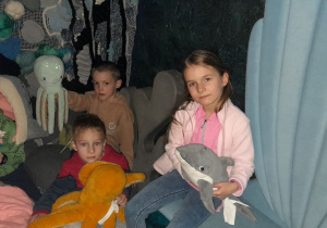 Dzieci odpoczywają w strefie relaksu, bawiąc się miękkimi elementami i pluszakami.