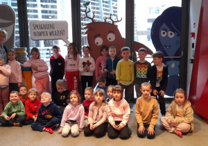 Wspólne zdjęcie Misiaczków z Panią Renatką na tle grafik żywiołów w EC1.