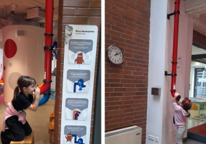 Oliwia i Maja bawią się rurami akustycznymi, sprawdzając, jak dźwięk się w nich przenosi.