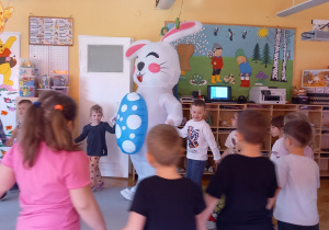 Dzieci tańczą w kole z zającem.