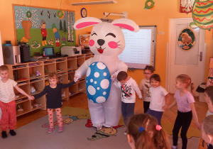 Zajączek trzyma za ręce dzieci.