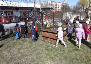 Krasnoludki szukają w ogrodzie jajek.