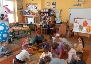 Zajączek przygląda się dzieciom jak układają duże puzzle.