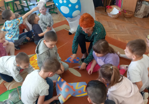 Pani Agnieszka z Żabkami układa na dywanie puzzle.