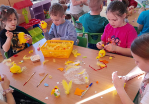 Dzieci wykonują kurczaczki z jajek.