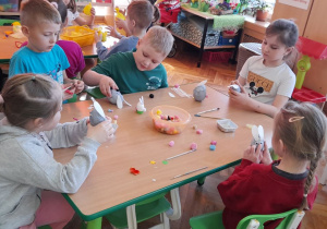 Przedszkolaki przygotowują zajączki z jajek.