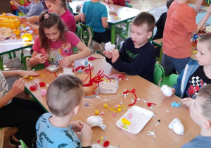 Dzieci wykonują baranki z jajek.