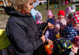 Misiaczki wkładają odnalezione jajka do koszyczka.