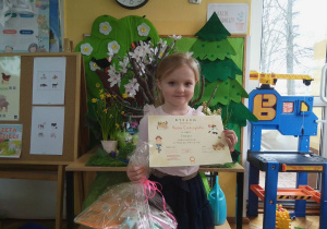 Hania pokazuje swój dyplom i nagradę.