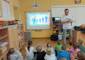Miły gość informuje dzieci ile wody jest w organizmie człowieka i jakie jest jej dzienne zapotrzebowanie.
