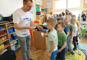 Sześciolatki otrzymują plakietki od miłego gościa.