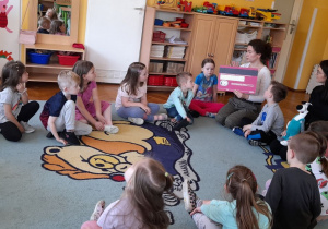 Pani tłumaczy przedszkolakom, co ważnego znajduje się na odwrocie karty.