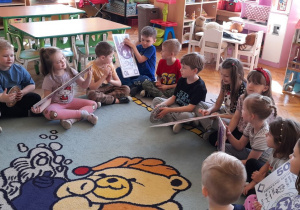 Dzieci z zainteresowaniem oglądają sylwety pieniędzy.