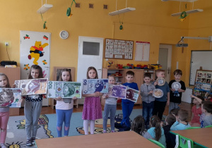 Przedszkolaki prezentują pieniądze ułożone wg wartości nominałów.