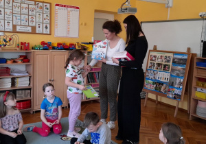 Latika z grupy Żabki otrzymuje dyplom i książkę z rąk Pani Izy.