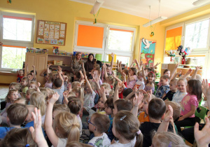 Dzieci, które oglądają bajki i grają w gry podnoszą ręce w górę.