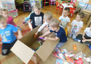 Dzieci z grupy Biedronek pakują prezenty.