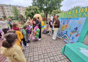 Burmistrz Łasku - Monika Mrowińska przekazuje dzieciom piłki.