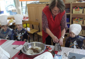 Pani Renia pokazuje składniki potrzebne do wykonania pierników i wsypuje je do miski.