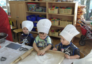 Dzieci z grupy Krasnoludków, ugniatają ciasto, które będą rozwałkowywać.