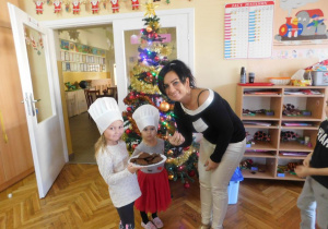 Dzieci częstują ciasteczkami panią Kamilkę.