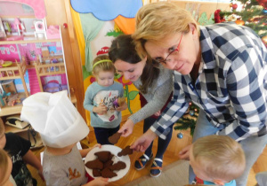 Dzieci częstują ciasteczkami panią Zosię i panią Anią.