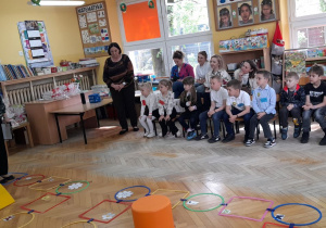 Pani Agnieszka Siemińska objaśnia dzieciom zasady gry.