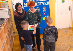 Nikodem wskazuje i nazywa na obrazku figury geometryczne.