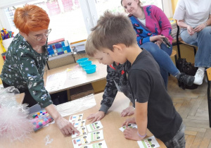 Pani Agnieszka Siemińska zwraca dzieciom uwagę na istotny szczegół zadania.