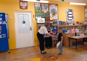 Pani Dyrektor gratuluje przedszkolakowi zdobycia I miejsca w grze.