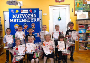 Wszyscy uczestnicy konkursu pozują do zdjęcia dyplomami i nagrodami.