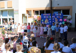 Dzieci z grupy „Słoneczek” stoją i śpiewają piosenkę „Mama i tata”.