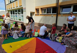 Uczestnicy siadają na chuście na wybranym kolorze