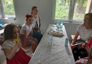 Dziewczynki i rodzice korzystają z poczęstunku.