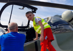 Kacper zagląda do wnętrza kokpitu, aby zobaczyć elementy wyposażenia.